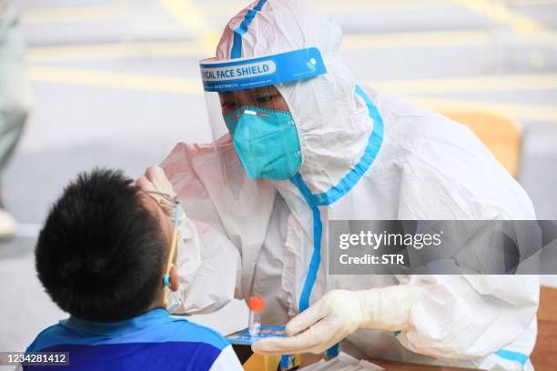 Child receives a nucleic acid test for the Covid-19 coronavirus in Nanjing, in eastern Jiangsu province on July 29, 2021. - China OUT / China OUT