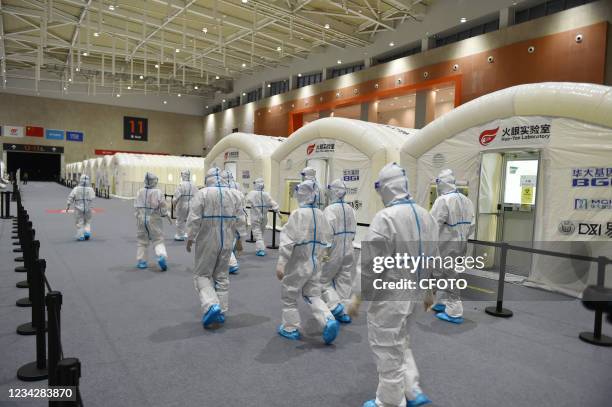 Medical staff prepare to enter the cabin, Nanjing, Jiangsu Province, China, July 28, 2021. The daily detection flux of Nanjing "Huo-Yan laboratory"...