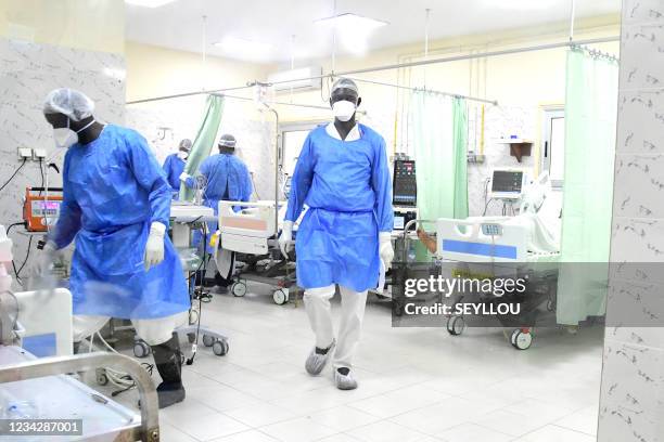 Health workers wearing personal protective gear are seen at the intensive care unit at the Idrissa Pouye de Grand Yoff Hospital, on July 28, 2021. -...