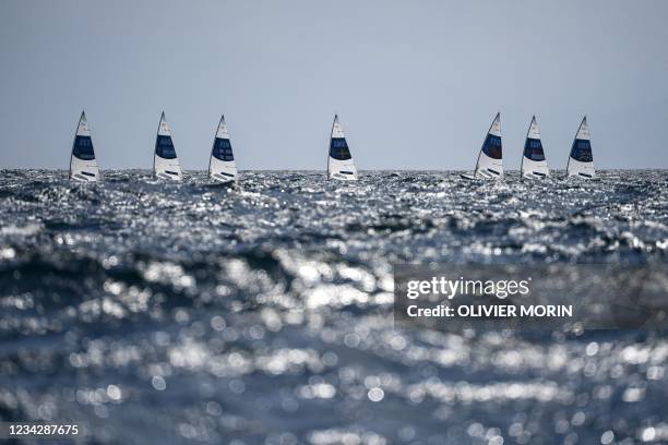 Competitors take part in the men's one-person dinghy laser race during the Tokyo 2020 Olympic Games sailing competition at the Enoshima Yacht Harbour...