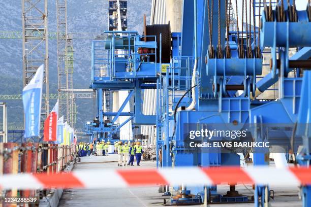 Engineers walk at the construction site while final elements of steel construction are being installed on the "Peljesac bridge", near the village of...