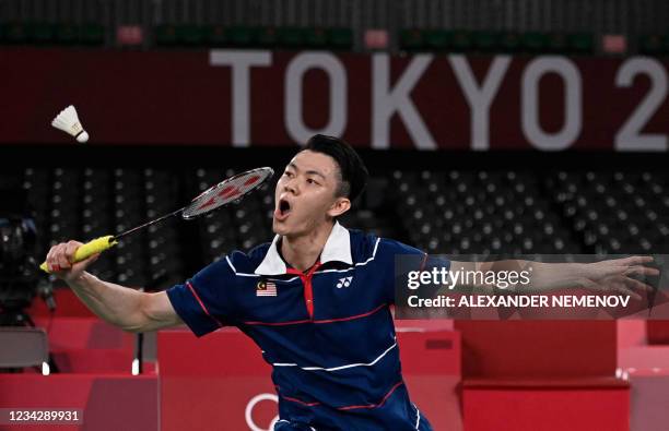 Malaysia's Lee Zii Jia hits a shot to China's Chen Long in their men's singles badminton round of 16 match during the Tokyo 2020 Olympic Games at the...
