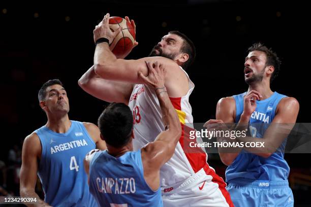 Spain's Marc Gasol goes to the basket as Argentina's Luis Scola and Facundo Campazzo watch in the men's preliminary round group C basketball match...