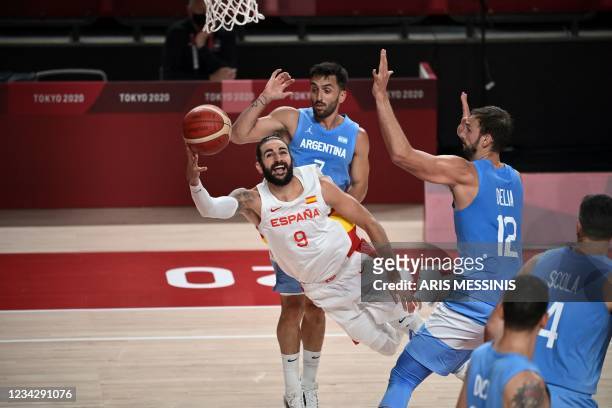 Spain's Ricky Rubio goes to the basket past Argentina's Facundo Campazzo and Marcos Delia in the men's preliminary round group C basketball match...