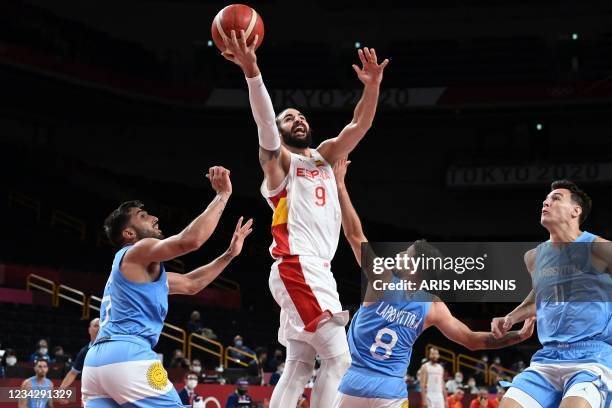 Spain's Ricky Rubio goes to the basket past Argentina's Facundo Campazzo and Nicolas Laprovittola in the men's preliminary round group C basketball...