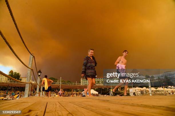 Dark smoke drifts over a hotel complex during a massive forest fire which engulfed a Mediterranean resort region on Turkey's southern coast near the...