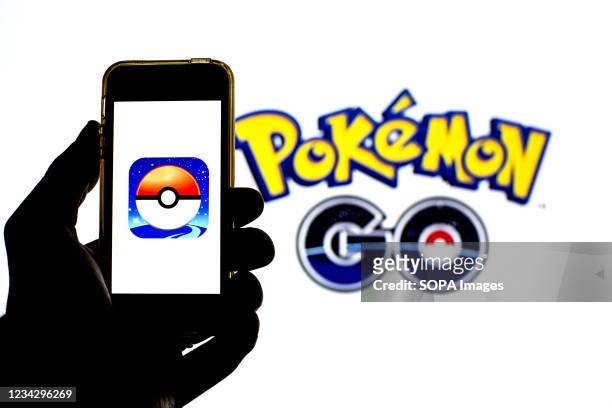 In this photo illustration a Pokémon GO app seen displayed on a smartphone and in the background.