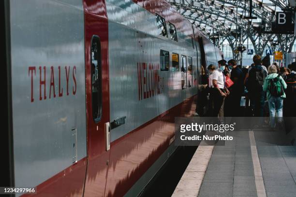 Travellers step into a Thalys train in the platform in Cologne central station, Germany on July 29, 2021 as germany plans restricter corona testing...