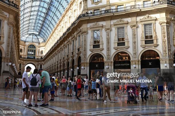 Picture taken on July 29, 2021 shows tourists and inhabitants strolling in the commercial gallery "Galeria Vittorio Emanuele II" near Duomo Square in...
