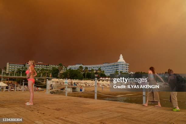 Dark smoke drifts over a hotel complex during a massive forest fire which engulfed a Mediterranean resort region on Turkey's southern coast near the...