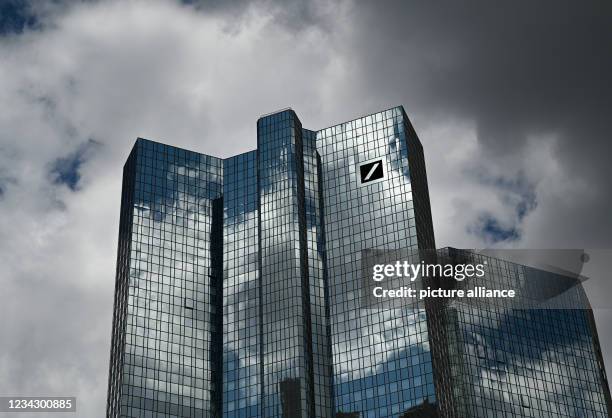 July 2021, Hessen, Frankfurt/Main: Clouds pass over Deutsche Bank's headquarters, while the cloudy sky is reflected in the façade. Photo: Arne...