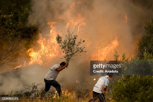 People try to contain a blaze after a massive forest fire broke out in Manavgat district and reached Yaylaalan neighbourhood of Antalya, Turkey on...