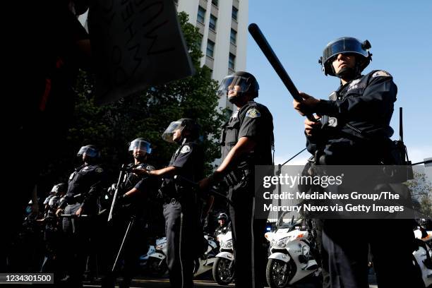 Police push protesters back on East Santa Clara Street during a protest decrying the police killing of George Floyd in downtown San Jose on Friday,...