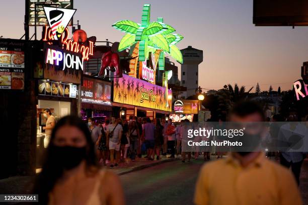 People walk by a bar in Albufeira, Portugal on July 29, 2021. Portuguese Prime Minister Antonio Costa announced on Thursday a three-stage plan to...