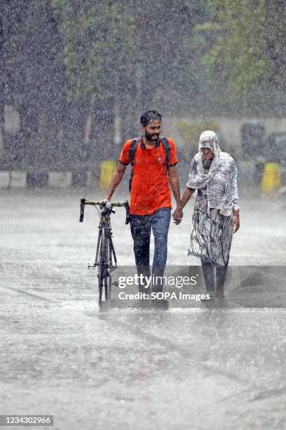 Couple seen walking along an empty and deserted road during a rainy day amid the covid-19 lockdown. The country went into a strict lockdown and Heavy...