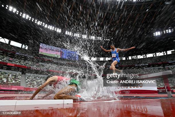 Morocco's Mohamed Tindouft falls next to Italy's Ala Zoghlami while competing in the men's 3000m steeplechase heats during the Tokyo 2020 Olympic...