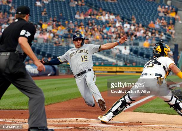 Tyrone Taylor of the Milwaukee Brewers scores on a fielders choice in the second inning against Michael Perez of the Pittsburgh Pirates during the...