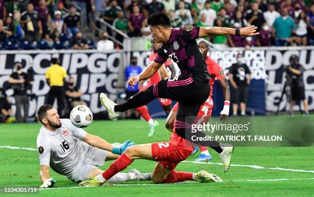 Mexico's midfielder Jesus Gallardo and Canada's defender Richie Laryea vie for the ball as Canada's goal keeper Maxime Crepeau blocks the shot during...