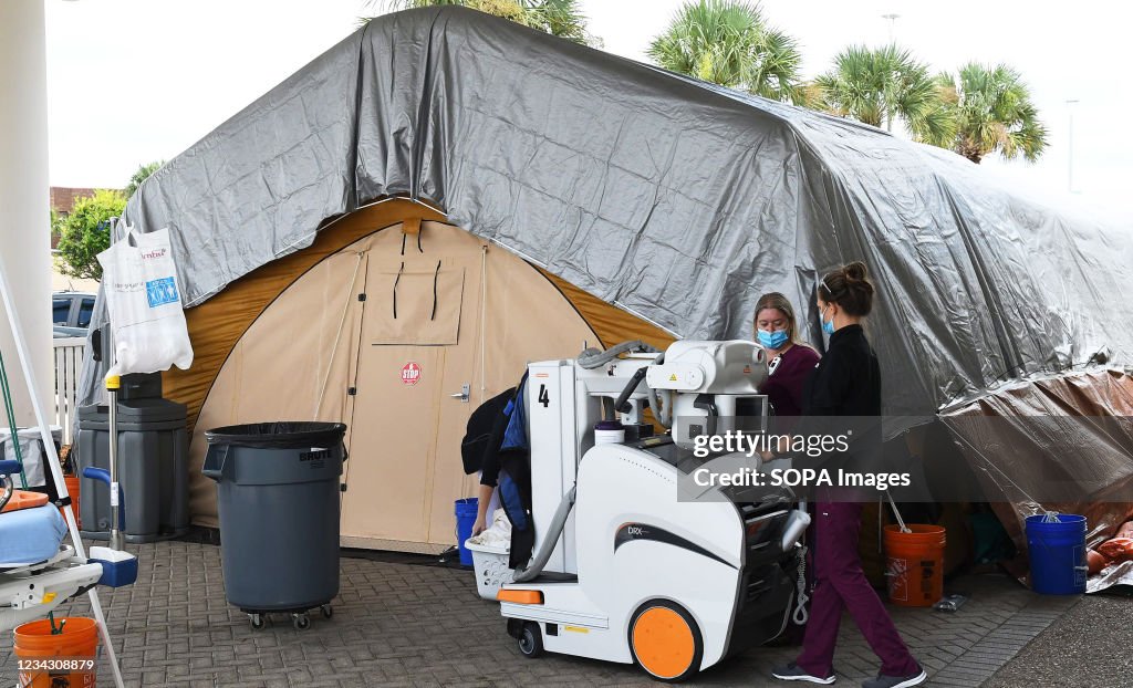 Nurses bring a portable x-ray machine to a treatment tent...