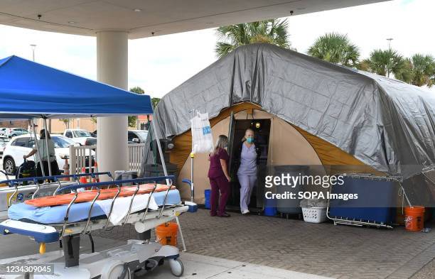 Nurses are seen at a treatment tent outside the emergency department at Holmes Regional Medical Center in Melbourne. The tent was set up to serve as...