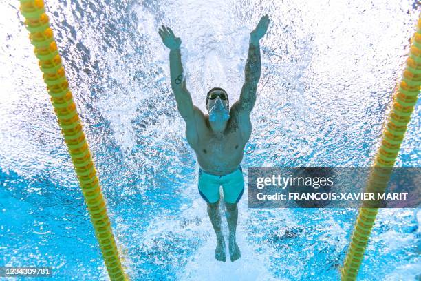 An underwater view shows USA's Caeleb Dressel competing in a semi-final of the men's 100m butterfly swimming event during the Tokyo 2020 Olympic...
