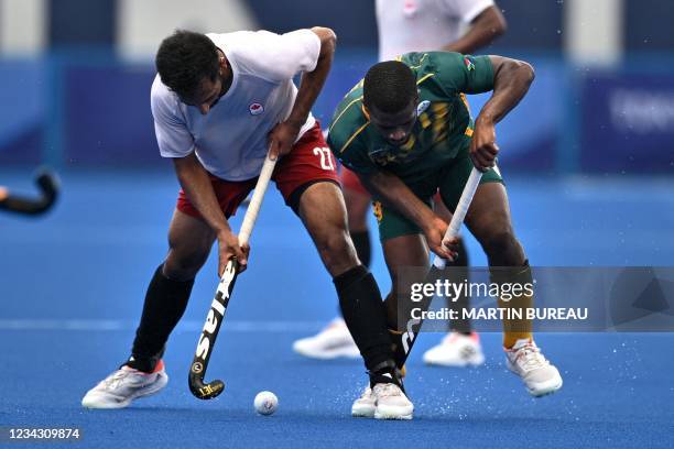 Canada's Sukhpal Singh Panesar is challenged by South Africa's Samkelo Mvimbi during their men's pool B match of the Tokyo 2020 Olympic Games field...