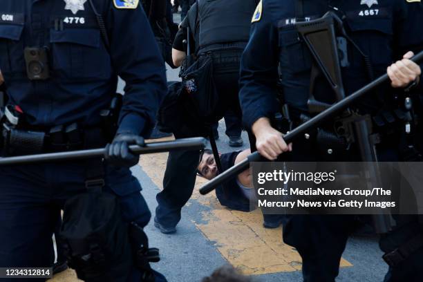 Protester is detained by San Jose Police officers during a protest on East Santa Clara Street in San Jose, Calif., on May 29 after the death of...