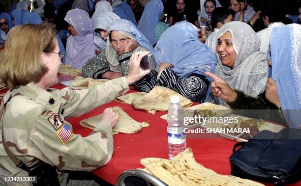 Colonel, Dawn Lake, shows a picture on her digital camera to Afghan women during the ceremony for launch of the US-led Provincial Reconstruction Team...