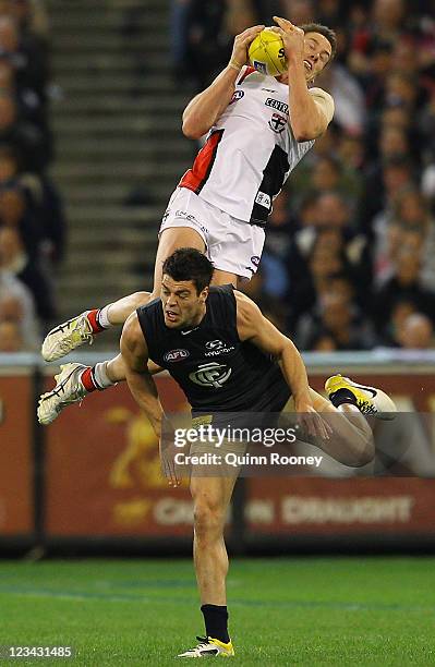 Jason Blake of the Saints marks over the top of Marcus Davies of the Blues during the round 24 AFL match between the Carlton Blues and the St Kilda...