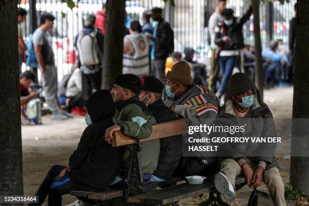 Migrants and homeless people wait to be relocated after spending the night in tents installed the day before during an action organised by the Utopia...