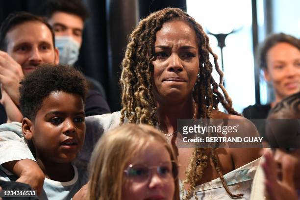 Luthna Plocus, the wife of French judoka Teddy Riner and their son Eden react as they watch a broadcast of his judo men's +100kg contest against...