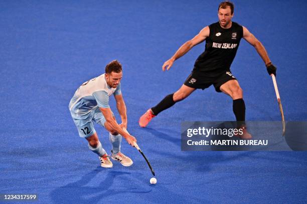 Argentina's Lucas Martin Vila dribbles the ball next to New Zealand's Nic Woods during their men's pool A match of the Tokyo 2020 Olympic Games field...