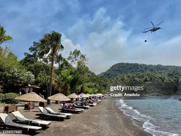 Helicopters respond the fire that broke out in Mugla's Marmaris district in Turkey on July 30, 2021. The forest fire started at noon yesterday in the...