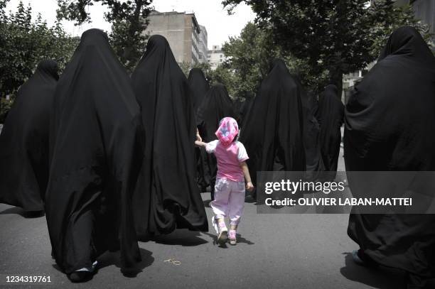 Iranian women walk in a street before the speech of Iran's supreme leader Ayatollah Ali Khamenei outside the Tehran University, on June 19, 2009....