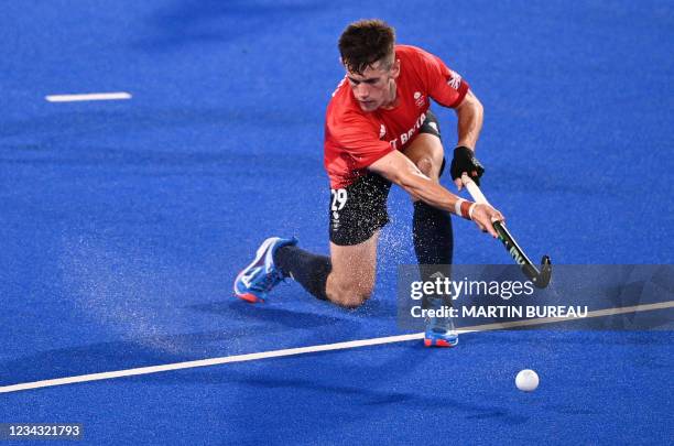 Britain's Thomas Sorsby strikes the ball during the men's pool B match of the Tokyo 2020 Olympic Games field hockey competition against Belgium, at...