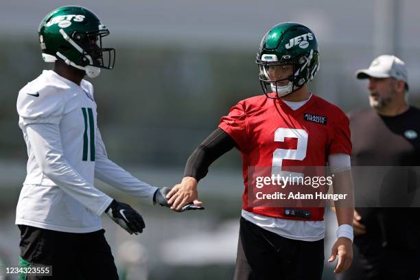 Zach Wilson of the New York Jets slaps hands with Denzel Mims of the New York Jets at Atlantic Health Jets Training Center on July 30, 2021 in...