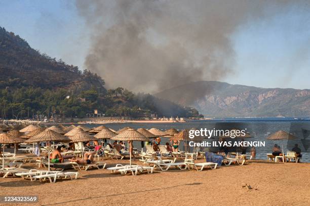 Tourists watch, from the beach, a massive wildfire which engulfed a Mediterranean resort region, on Turkey's southern coast, near Marmaris, on July...