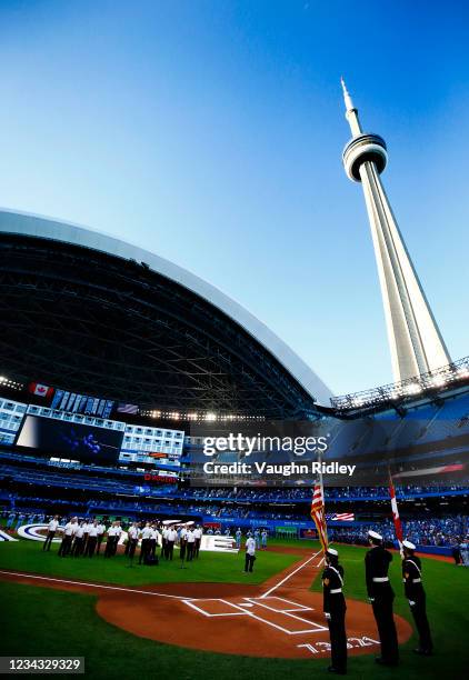 The Toronto Blue Jays line up behind a 'Home' sign to commemorate their first home game in Toronto this season prior to a MLB game against the Kansas...