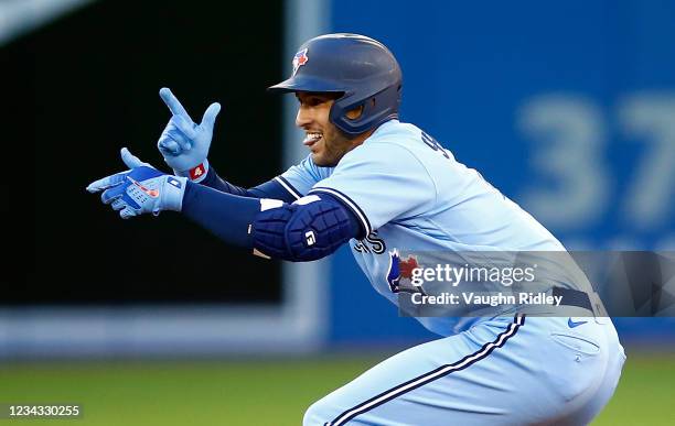 George Springer of the Toronto Blue Jays reacts after hitting a double in the second inning during a MLB game against the Kansas City Royals at...