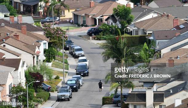 Man walks along a street in a neighborhood of single family homes in Los Angeles, California on July 30 a day before a nationwide ban on evictions...