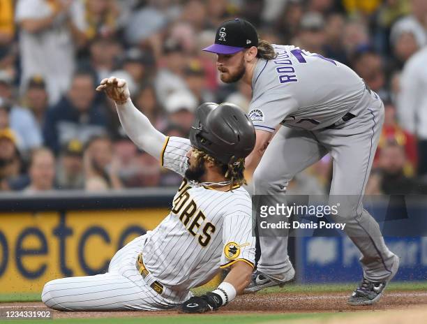 Fernando Tatis Jr. #23 of the San Diego Padres is tagged out at third base by Brendan Rodgers of the Colorado Rockies during the first inning of a...
