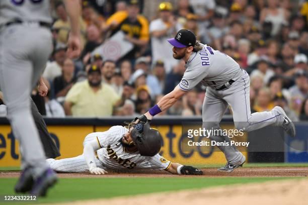 Fernando Tatis Jr. #23 of the San Diego Padres is tagged out at third base by Brendan Rodgers of the Colorado Rockies during the first inning of a...