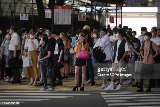 Pedestrians wearing face masks wait for a green light at a cross road in Shinjuku. 3300 people have tested positive for the Novel Coronavirus on day...
