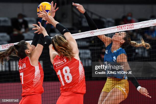 Argentina's Julieta Lazcano hits the ball in front of Turkey's Zehra Gunes and Hande Baladin in the women's preliminary round pool B volleyball match...