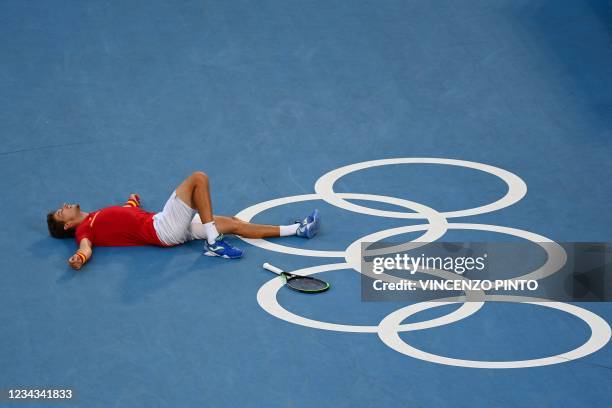 Spain's Pablo Carreno Busta celebrates after defeating Serbia's Novak Djokovic during their Tokyo 2020 Olympic Games men's singles tennis match for...