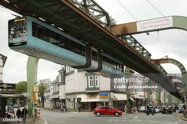 July 2021, North Rhine-Westphalia, Wuppertal: A suspension railway runs along Kaiserstrasse in the Vohwinkel district of Wuppertal. In Wuppertal,...