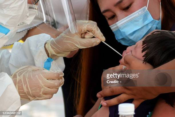 Child receives a nucleic acid test for the Covid-19 coronavirus in Zhengzhou, in China's central Henan province on July 31, 2021. - China OUT / China...