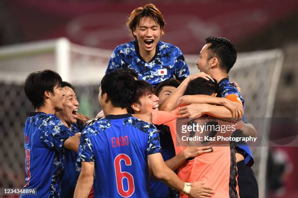 Japanese players celebrate with Kosei Tani who saves the penalty kick in the penalty shoot out during the Men's Quarter Final match on day eight of...