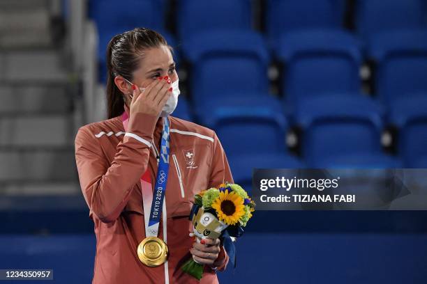 Gold medallist Switzerland's Belinda Bencic wipes a tear as she poses with her medal during the Tokyo 2020 Olympic Games women's singles tennis medal...