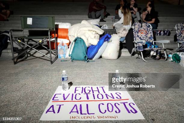 Sign calling for fighting evictions is set on the ground as Rep. Cori Bush spends the night outside the U.S. Capitol to call for for an extension of...